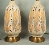 Lot 921:  Pr Retro Incised Pottery Base Lamps.  Textured leaf design. Openings in ceramic body allow light to shine through. Gold metal base: Dimensions:  H: 35 inches: W: 10 inches: D: 10 inches --- 