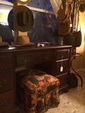 Classic mahogany knee-hole desk with with bat wing pulls , vintage print ottoman, camera and saddlebags