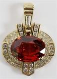 Lot#93, 16.52CT NATURAL SPESSARTITE & DIAMOND PENDANT, GIA, L 1 1/2"18kt yellow gold lady's pendant, featuring a 16.52 carat natural dark orange-red oval brilliant cut spessartite stone prong set at the center, surrounded by 2.00 carats of round and baguette side diamonds. Measuring L. 1 1/2" x 1 1/8", with a total approximate weight of 15.5 grams. GIA report included.