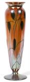 Lot#1003, DURAND IRIDESCENT ART GLASS VASE, EARLY 20TH C., H 12"Shape #2011, footed tapering form with a flared lip, orange iridescent glass, decorated in a pulled leaf on vine motif. Polished pontil at underside signed and numbered 2011-12 {see fifth photograph}. Measuring H. 12" x 3". Early 20th Century.
