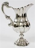 Lot#1007, BUCCELLATI, ITALIAN STERLING PITCHER, H 10", W 8"A sterling silver footed pitcher, fitted with a scroll form handle. Measuring H.10" x 8", with a total approximate weight of 24.073 tr.oz.