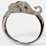 Lot#1056, 18KT WHITE GOLD & DIAMOND ELEPHANT BANGLE BRACELET, W 2 3/8" X 2"18kt white gold lady's elephant form bangle bracelet, lined with round diamonds, and a round sapphire stone at each eye. The bangle bracelet's opening measures L.2 3/8" x 2", having a total approximate weight of 52.6 grams.