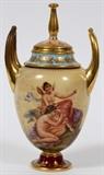 Lot#1073, ROYAL VIENNA PORCELAIN COVERED URN, 19TH C., H 7", W 4"Covered urn, flanked by fired gold handles, and decorated with a scene of Amor & Psyche at one side, and a seated semi-nude female with flower at the other. Marked at the underside, measuring H. 7 1/4" x 4", circa 19th Century.