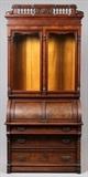 Lot#1118, VICTORIAN BURL WALNUT CYLINDER-FRONT SECRETARY, C. 1870, H 89", W 43", D 23"A secretary fitted with a pair of glass paneled doors, above three drawers. Having a center cylindrical roll drop front, which opens to an interior of two drawers and seven slots. Carved with fretwork design and spindle gallery along the top. Measuring H. 89" x 43" x 23". American Eastlake, circa 1870.