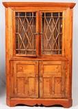 Lot#1119, ANTIQUE PINE CORNER CABINET, H 82", W 56", D 17"Electrified.  The upper section features two doors, with wood lattice, which open to reveal two shelves.  Two sets of upper shelves, one wood and the other glass.  Lower section also has two doors which open to reveal a single shelf.  Measures H.82 1/4" x 56" x 17".