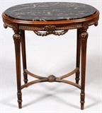 Lot#1123, FRENCH CARVED WALNUT & MARBLE CENTER TABLE, H 28 3/4", W 30", D 20"An oval black marble top raised on fluted tapering supports joined by stretchers.  Measures H.28 3/4" x 30" x 20 1/2".  Early 20th century.
