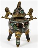 Lot#1284, CHINESE CLOISONNÉ INCENSE BURNER, LATE 19TH C., H 9 1/2", W 8"Globular-form body flanked by Fu dog handles, the domed cover is centered by a Fu dog finial, raised on three supports with Fu masks; colorful floral sprays on a black ground.