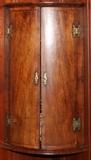 Lot#2171, ENGLISH WALNUT HANGING CORNER CUPBOARD, C. 1720, H 40", W 23", D 16"Queen Anne or early Georgian, walnut with oak secondary wood, quarter round form having inlaid panels with feather banded borders; the pair of doors open to three shelves (see additional photo).  Brass hardware includes butterfly hinges with incised designs.  Provenance: Purchased from Church Street Galleries Limited, London, April 1985.
