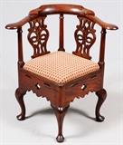 Lot#2172, GEORGE III MAHOGANY CORNER CHAIR, C. 1760-80.An encircling chair rail above two pierced splats and an upholstered seat, raised on cabriole legs ending in pad feet.