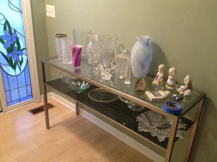 Glass sofa table with collection of cut glass vases, waterford bowl, and other collectibles