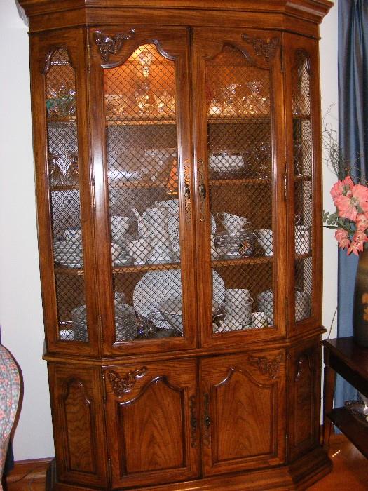 Beautiful carved and embellished vintage china cabinet is solid wood, lighted, with latticed glass.  (Does not include contents)  $995.00