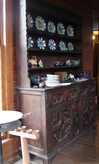 Welsh cupboard in the Medieval style. Talavera plates. Disk grill on far left. Interesting candle holder.