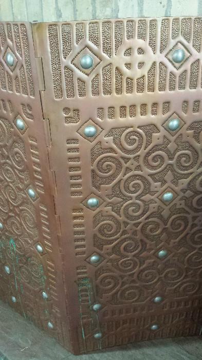 Detail of one of the fire screens designed by Isaac Maxwell. Copper is the primary metal.