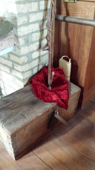 Rustic wood chest, swatch of crushed red velvet and a knarlly wood walking stick.
