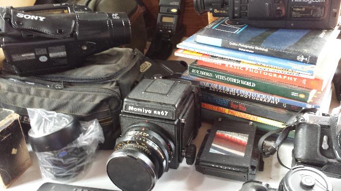 Assorted camera equipment and related books.