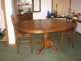 oval pedestal dining table (shown w/leaf in) and four (two shown) ladder back chairs, also have table pads 