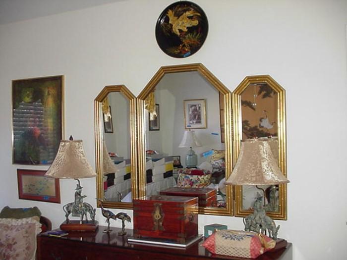 Another view of the dresser, mirror, lamps, and art work
