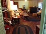 Den.  Sofa, three easy chairs, recliner.  Wooden ladies rocker.  Two oval area rugs.  Two end tables, coffee table, lamp table.