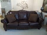 Leather couch (7ft) with pillows, ornate wood trim