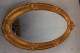 313 - Oval  hanging mirror in gold frame, 50 x 26