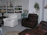 Foreground includes a leather rocker/recliner and sofa with media storage and rocker/recliner ends. One of a pair of covered chairs is shown. The table is a Hooker Seven Seas. The lamp is one of a half dozen. The painted six drawer chest behind the leather recliner is one of a dozen painted pieces for sale. More Fiesta, Hall, etc. lines the bookcase.
