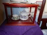 Teapot, cup, and saucer in glass show case
