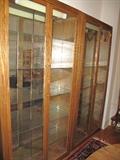 Pair of lighted, tall oak double door display cabinets.