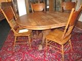 Round oak table with claw feet & two leaves. Nice set of oak pressed back chairs.
