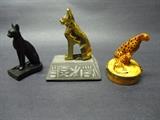 An assortment of Cat related figurines, first one is a bronze figure marked MMA (Metropolitan Museum of Art), the second Gilded Egyptian cat on a marble base and the third, A Limoges Cheetah snuff box