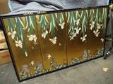 Oriental Screen that has been re-purposed. The screen is set upside down due to the brass brackets on the lower section