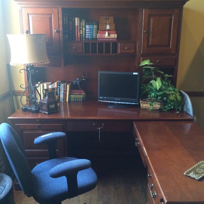 L-shaped desk unit; office chair; monitor; books; decorative items