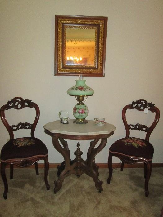 Deeply carved side chairs with needlepoint seats, marble turtle top table, handpainted vintage lamp (as is), antique mirror