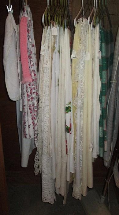 Various table cloths (some crocheted), aprons