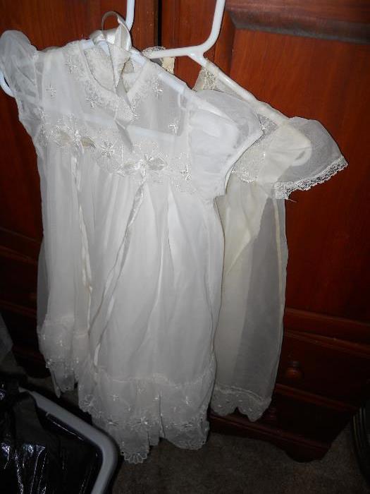 2 White Christening Dresses hanging on Oak Dresser