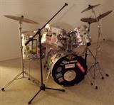 Slingerland Drum Set, newer, not-vintage: 5-pc with Slinglerland-labeled high-hat & cymbals, includes extra Tama Bass Pedal, Pearl COW BELL, an old Vintage Jazz Crash Cymbal and sticks/stick-bag (Silver, but covered in Stickers representing 80’s & 90’s counter-culture bands / skateboards / BMX).