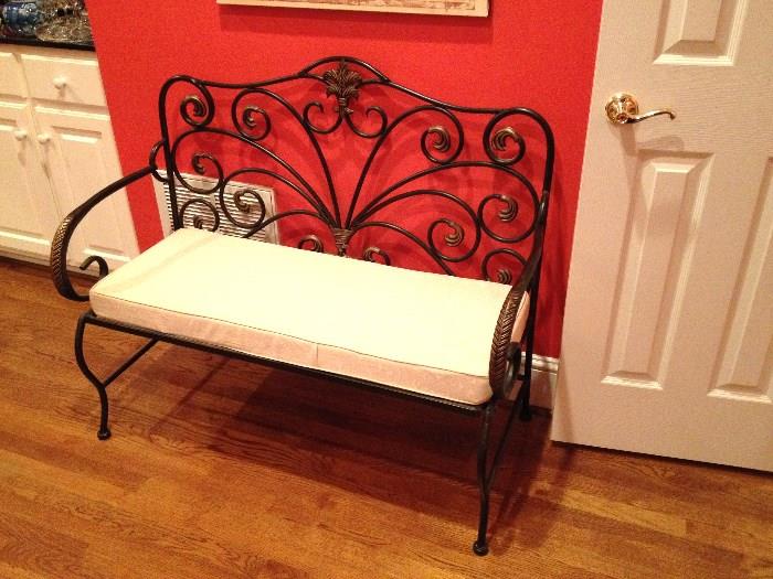 Decorative wrought iron bench with upholstered cushion