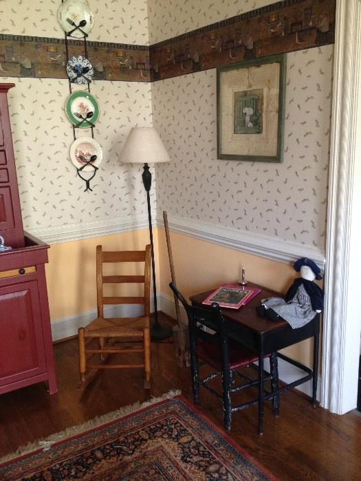 Vignette with small wooden rocker, child's desk and chair, floor lamp 