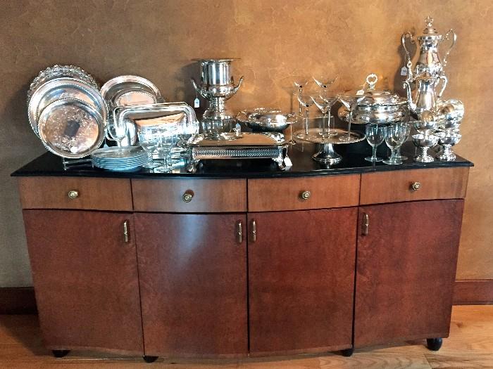 Amazing selection of silver plate serving pieces sitting atop of this stunning buffet server