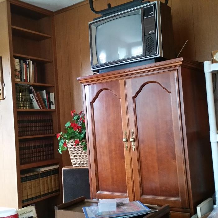 books; armoire; VHS tapes; televisions (one in the armoire)