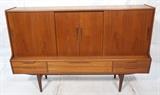 Lot 389:  Danish Modern Teak Sliding Door Cabinet. Interior Bar section with mirror back. Five drawers. Raised on legs.: Dimensions:  H: 50.25 inches: W: 78.75 inches: D: 19.75 inches --- 