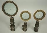 Lot 421:  3pc Industrial Magiscopes Table Top Sculptures. Glass discs in metal cog frame on cam shaft base. Engraved mark: Feliciano Bejar: Dimensions:  H: 10 inches: W: 4.5 inches --- 
