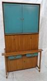 Lot 563:  Two Part Tall American Modern Bar Cabinet. Green Turquoise Painted Doors. Detailed Wood Cabinet. Brass banded legs. Hickory Manufacturing Co: Dimensions:  H: 82 inches: W: 49.5 inches: D: 21 inches --- 