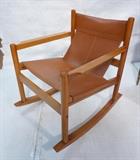 Lot 539:  Scandinavian Tan Leather and Wood Rocking Chair. Sling form seat. : Dimensions:  H: 33 inches: W: 26.25 inches: D: 32 inches --- 