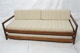 Lot 675:  JENS RISOM style Modern Walnut Trundle Daybed. Walnut frame sides. Two tiers of oatmeal fabric upholstered cushions. Bottom bad comes out and can be raised to meet top bed. Not marked; attribution. : Dimensions:  H: 23.5 inches: W: 80 inches: D: 38 inches --- 