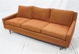 Lot 678:  Modern Rust Upholstered Sofa Couch. Tapered peg legs. : Dimensions:  H: 28.5 inches: W: 76 inches: D: 32 inches --- 