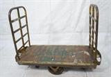 Lot 685:  Large Industrial Rolling Cart. Double iron handles on slatted wood cart. Handles are removable.: Dimensions:  H: 51 inches: W: 69 inches: D: 27 inches --- 