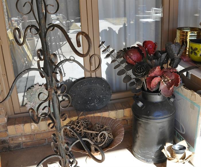 Large metal flowers and a tall wrought iron hanging plant "tree"