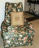One of two chairs in green background fabric with white's, brown's and blue flowers.