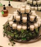 3-tier black candle stand with green ivory in bathroom.