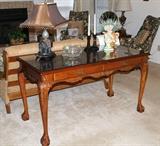 Close-up of the desk/sofa table in living room. Has beautiful wood and legs. Also has piece of glass that fits the top.